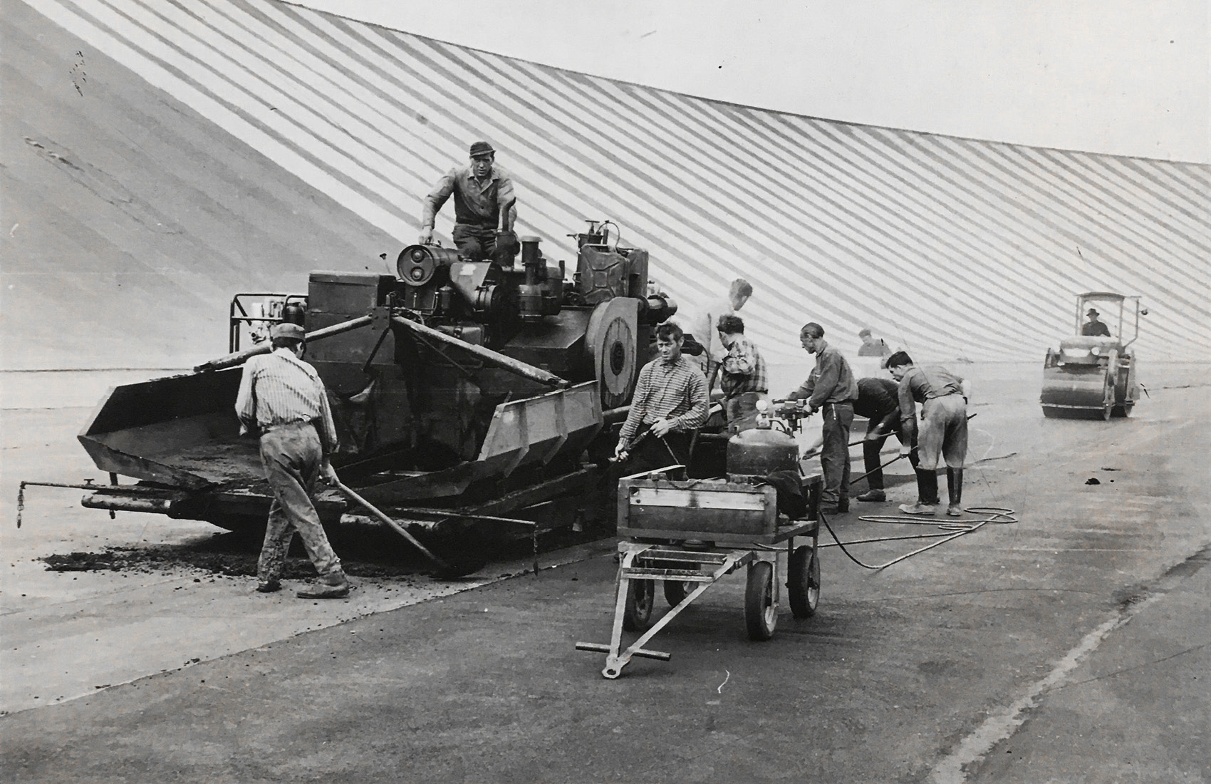 alte schwarzweiß Fotografie einer Teermaschine und dem Bau einer neuen Straße