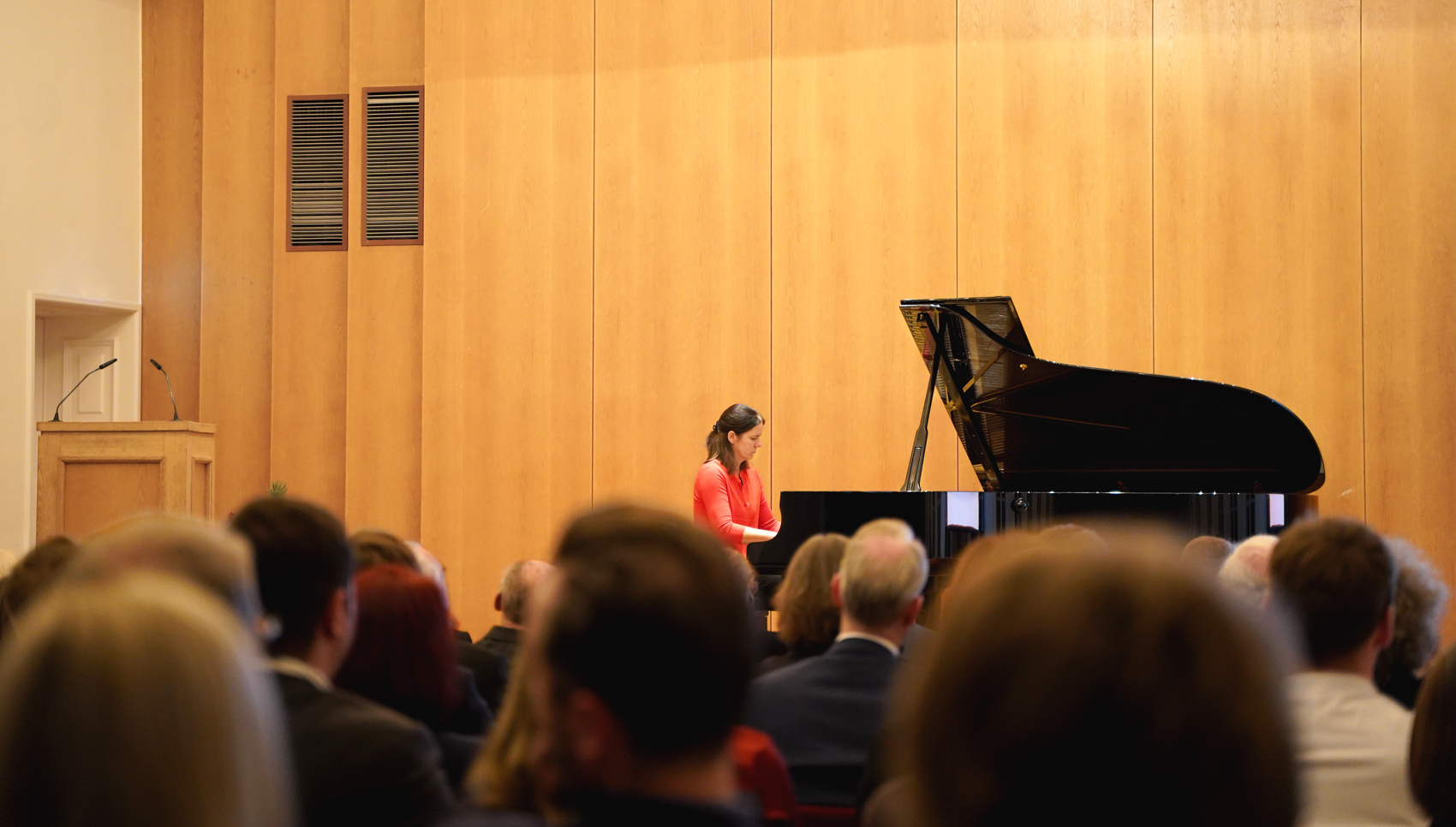 Eine Frau, die gerade auf einem Konzertflügel spielt.