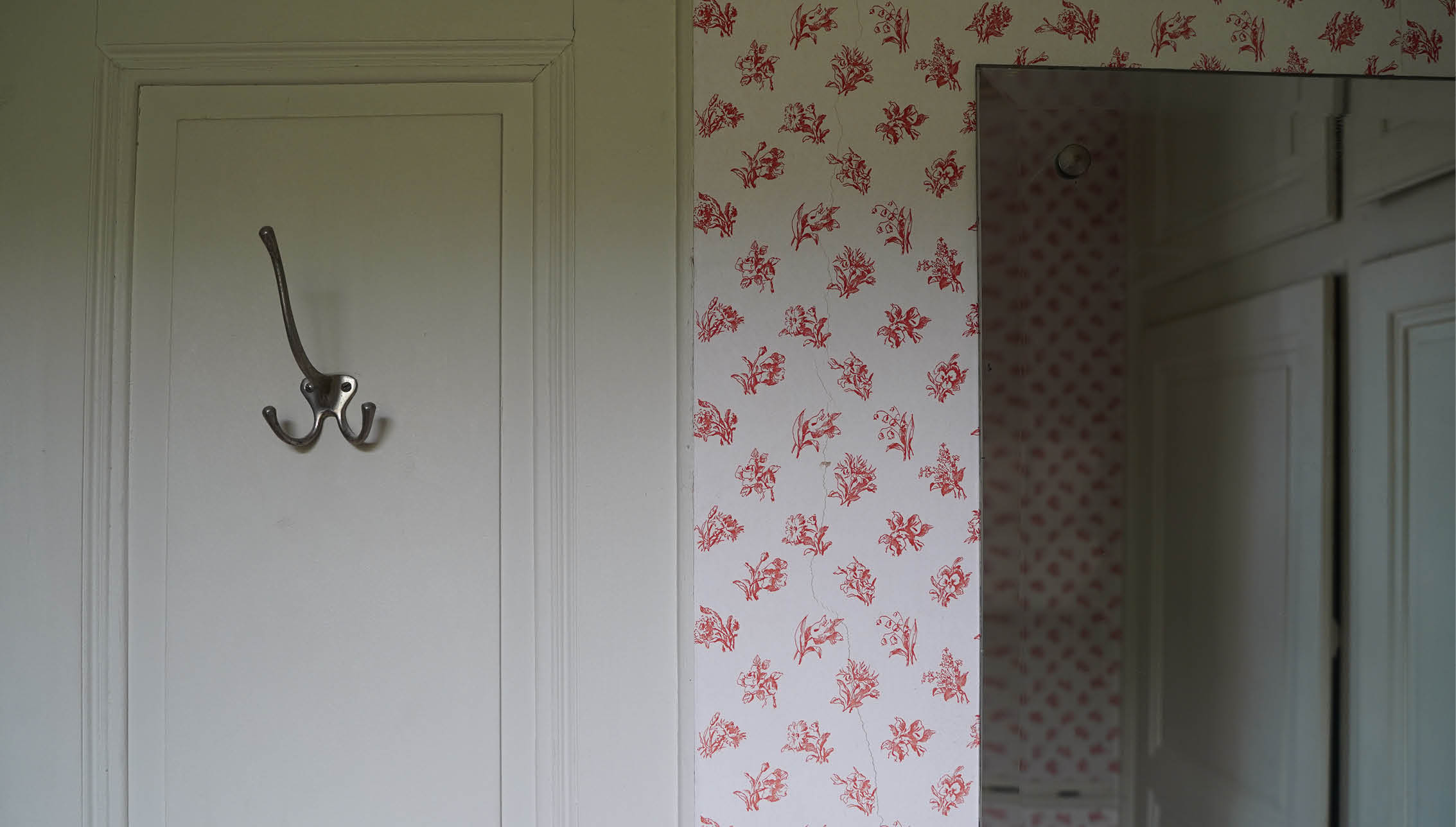 Detailaufnahme einer weißen Tapete mit rotem Blumenmuster