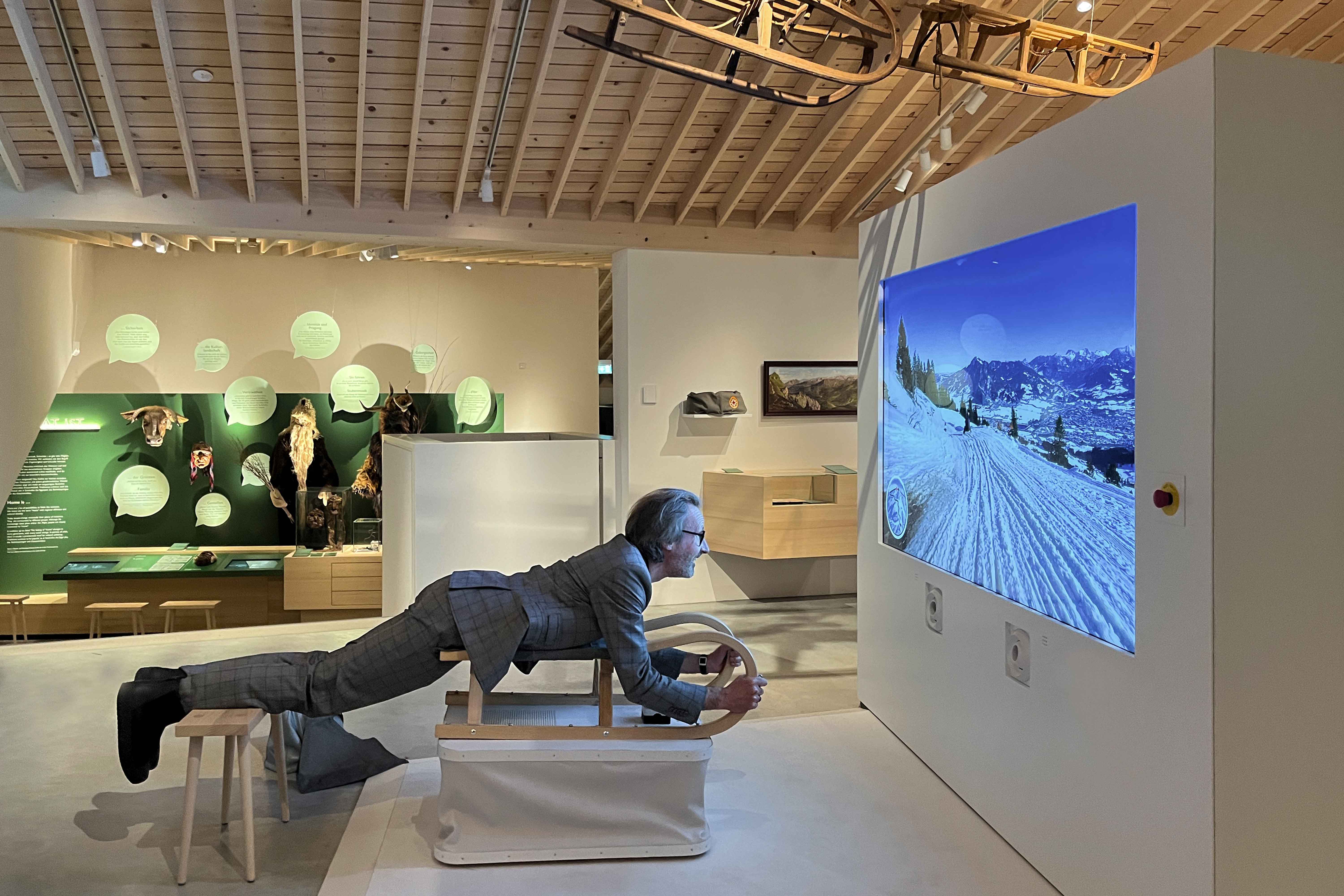 Ingo Plato liegt auf dem Schlitten, der eine virtuelle Rodelfahrt steuert.