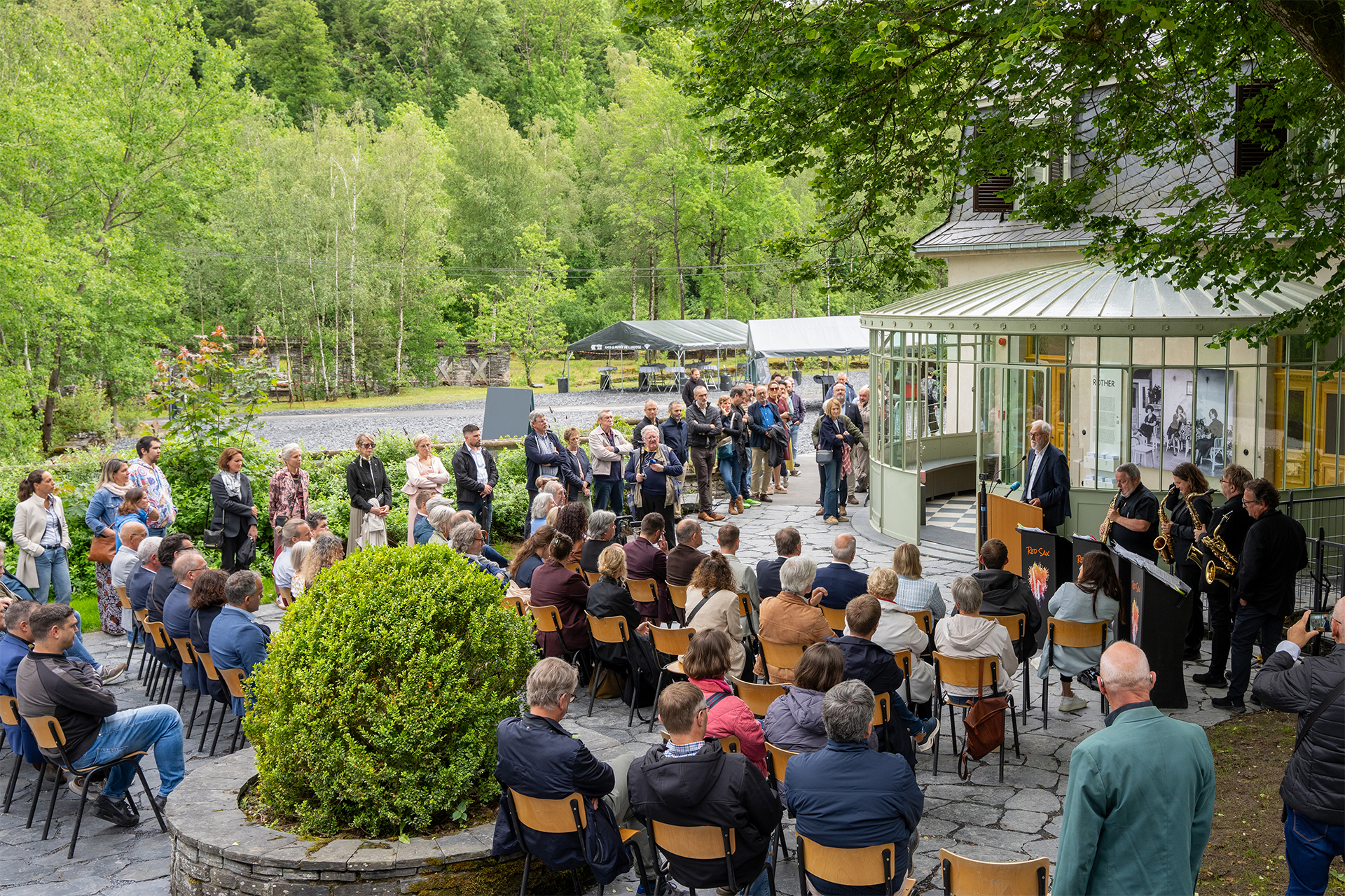 sitzende Besuchende lauschen Blasmusik