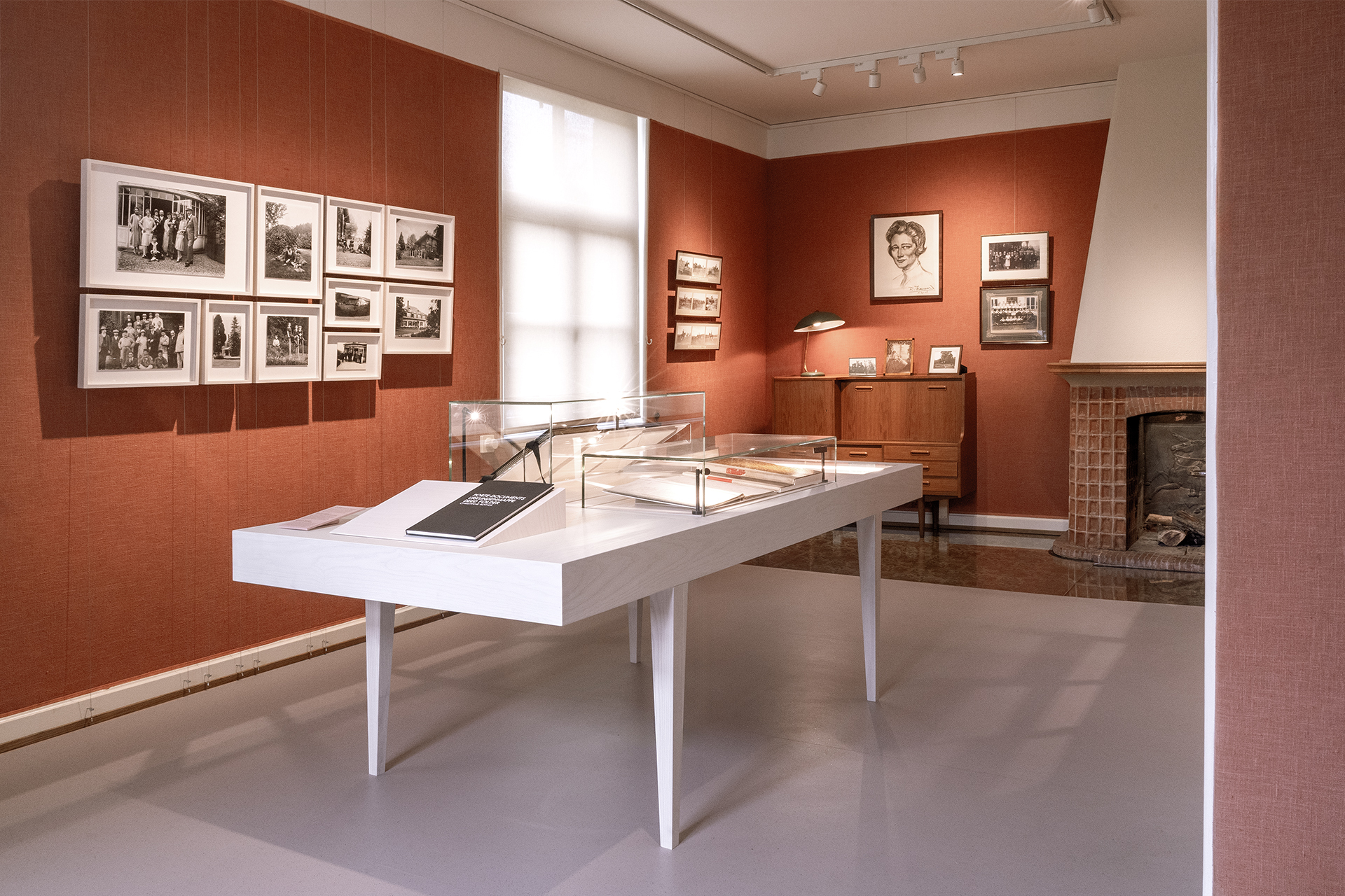 Ausstellungsraum mit Vitrinen und abgehängten Fotografien