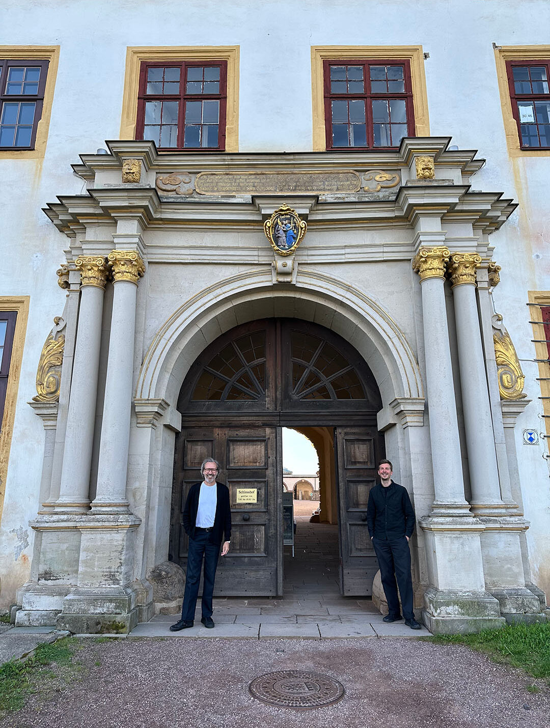 Ingo Plato und Alexander Hesse stehen vor dem stadtseitigen Hauptportal von Schloss Friedenstein in Gotha