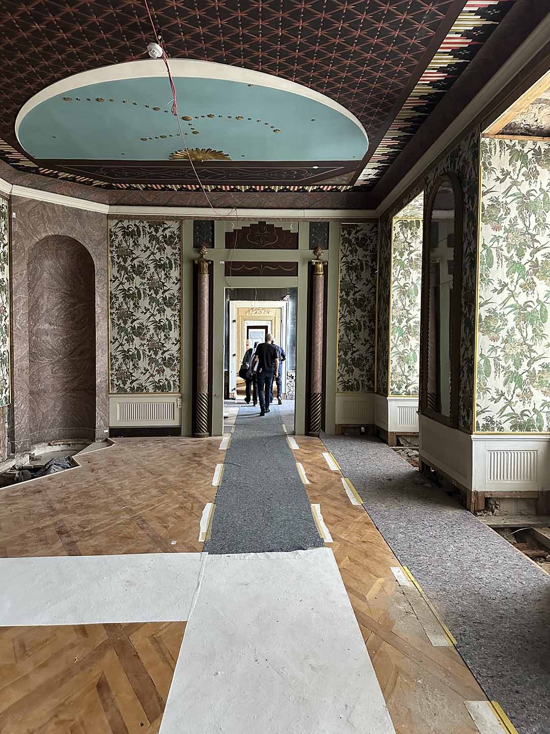 Restaurierungsarbeiten in einem historischen Raum von Schloss Friedenstein mit Blumentapeten und bemalter Decke